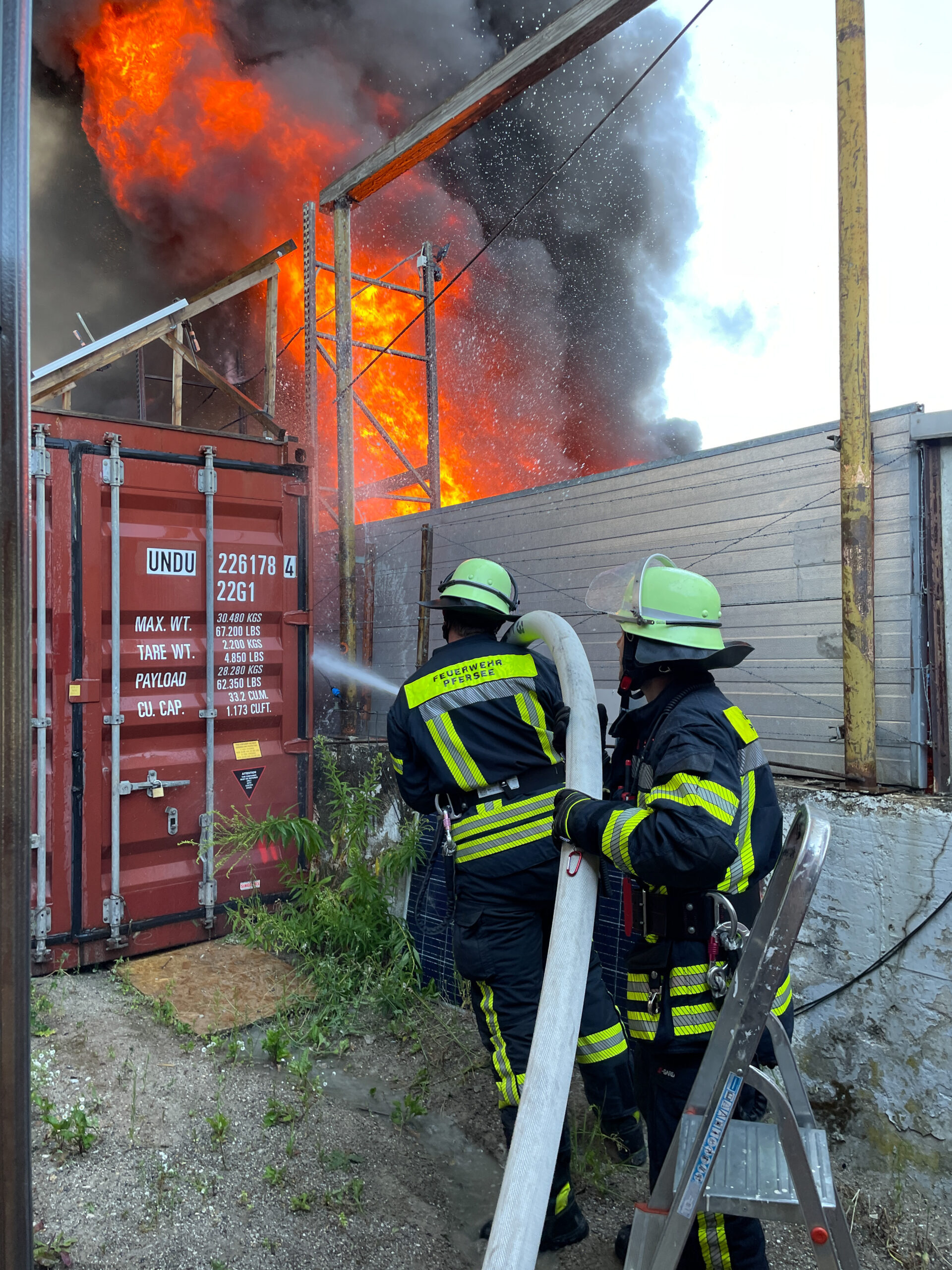 Einsatzbild: Zwei Feuerwehrmänner löschen die Flammen