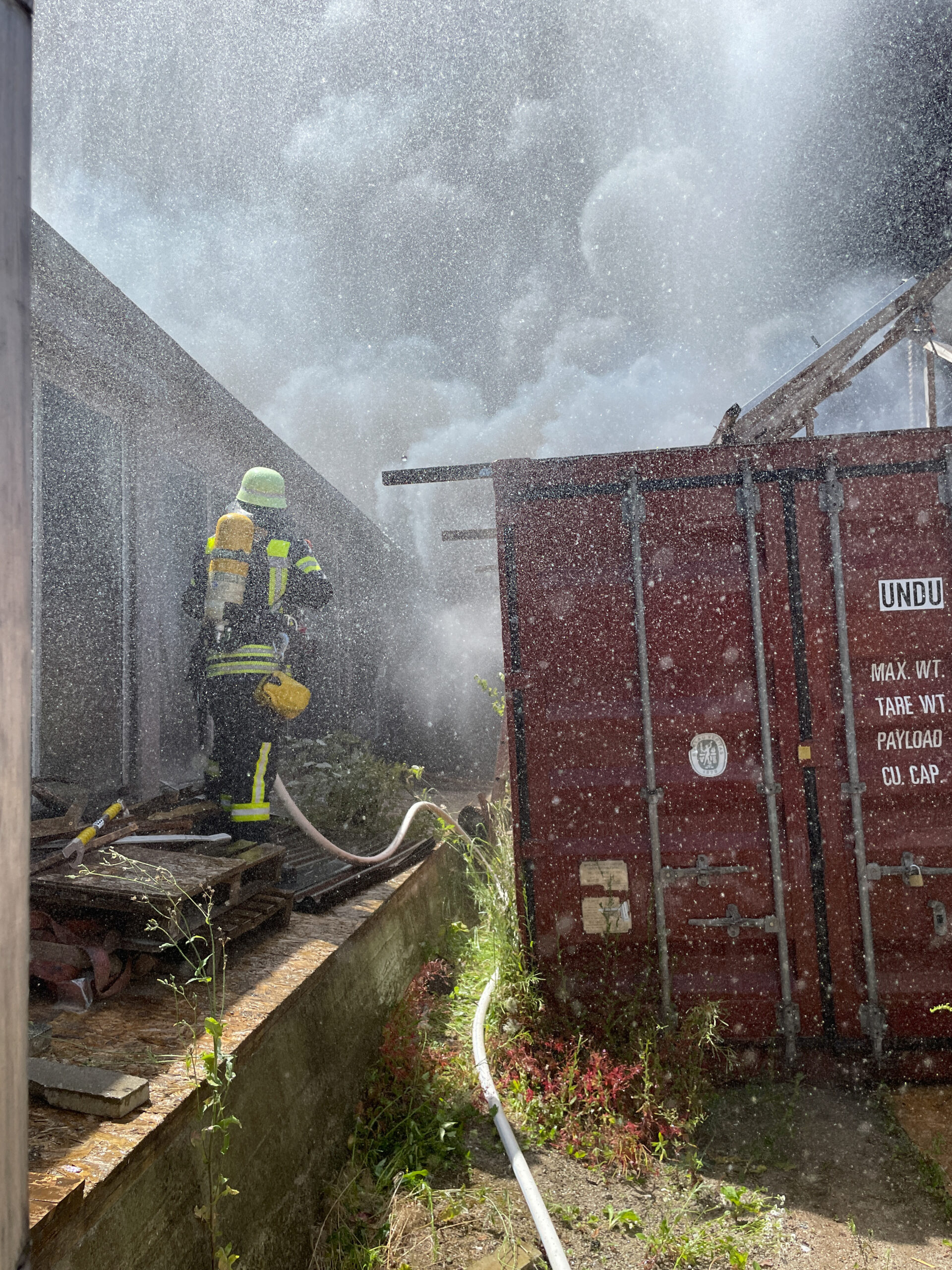 Einsatzbild: Feuerwehrmann löscht unter Atemschutz Großbrand