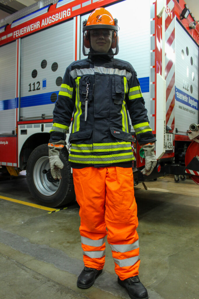 Feuerwehrmann mit Schnittschutzhose und Motorsaegenhelm